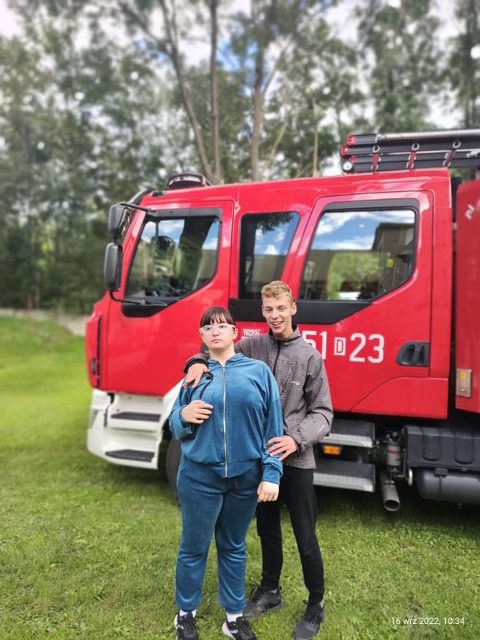hdimg01a0d70fcb8610fd3e9b064cf4f5d6 dwójka uczniów, za nimi wóz strażacki